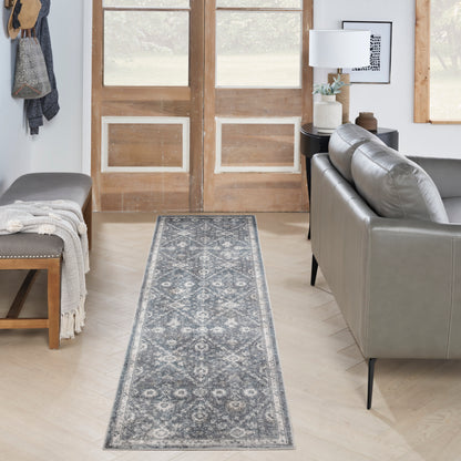Blue-gray patterned 6' runner rug in a light-wood foyer, flanked by a gray sofa and a bench.