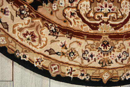 Round oriental-style rug with cream, tan and brown floral patterns on a light wood floor.