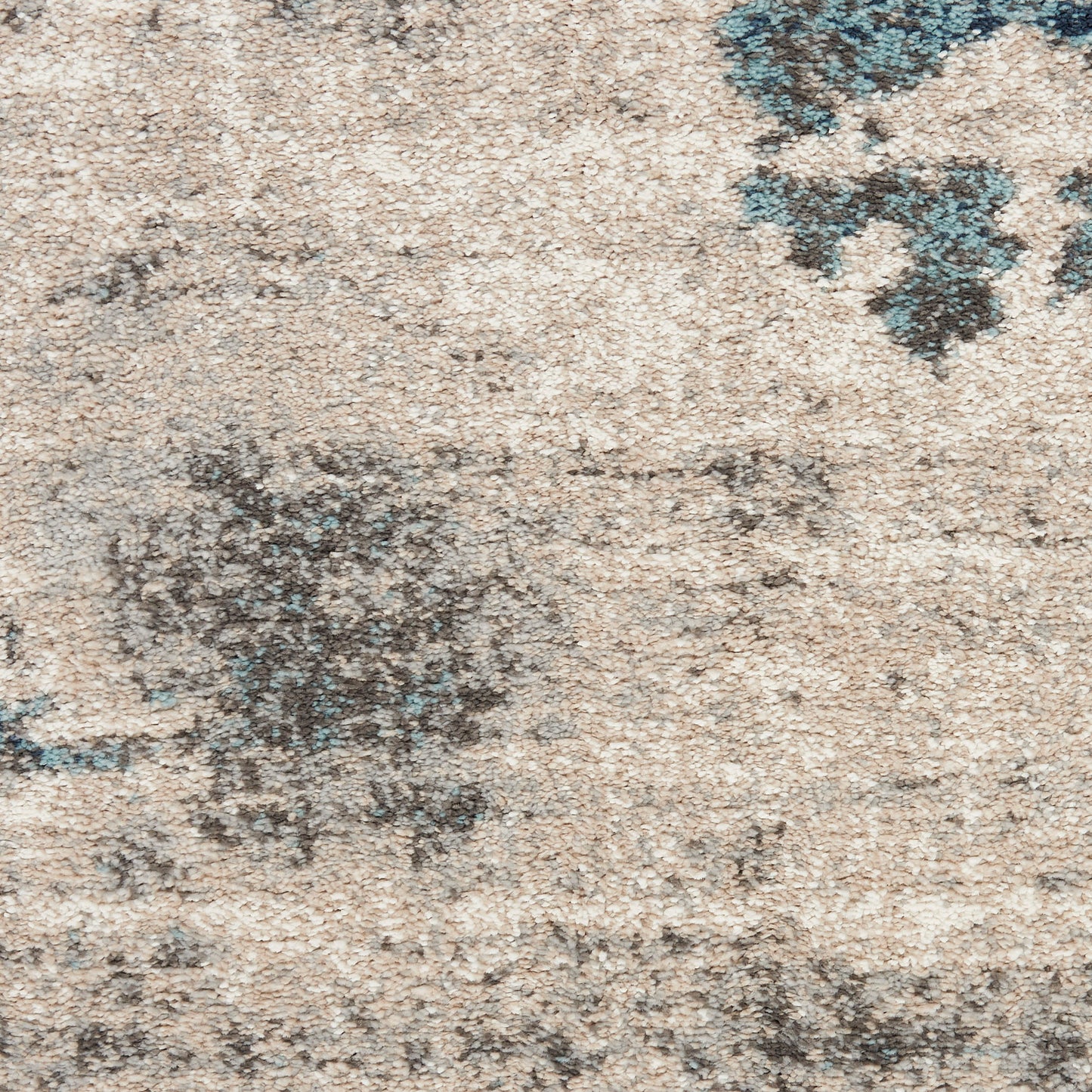 Beige distressed rug with muted blue floral accents and a soft, textured pile.