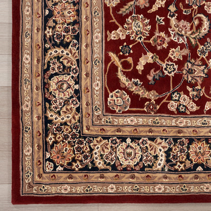 Corner of a Persian-style rug: burgundy field with ivory, navy and gold floral motifs, rich multi-border trim.