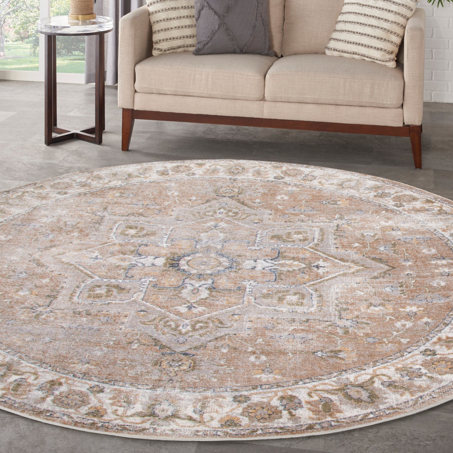Round beige oriental rug with muted blue-gray accents and floral medallion border in a modern living room.
