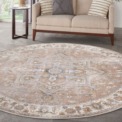 Round beige oriental rug with muted blue-gray accents and floral medallion border in a modern living room.