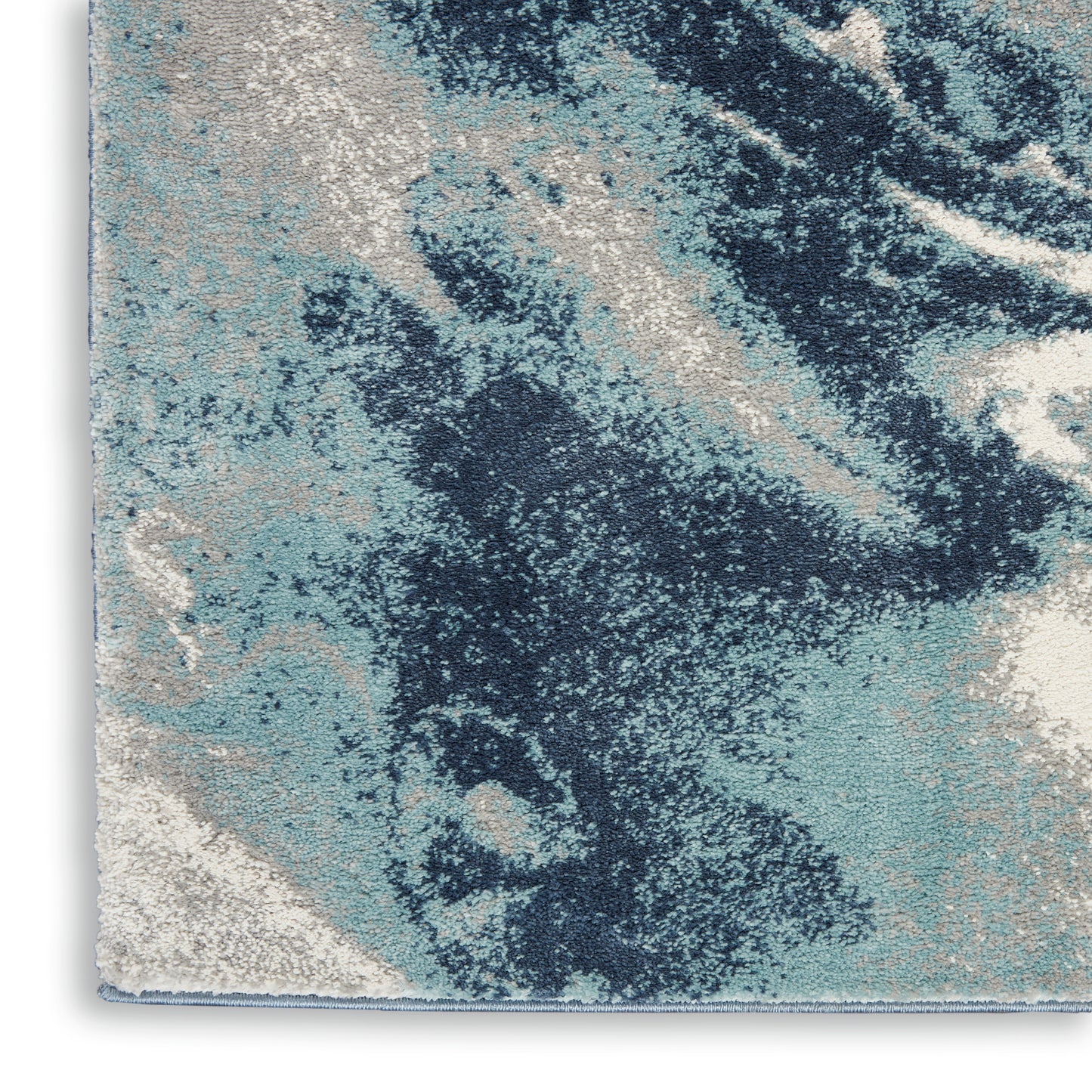 Abstract blue, teal and ivory rug with textured pile and marbled pattern for modern living room decor.