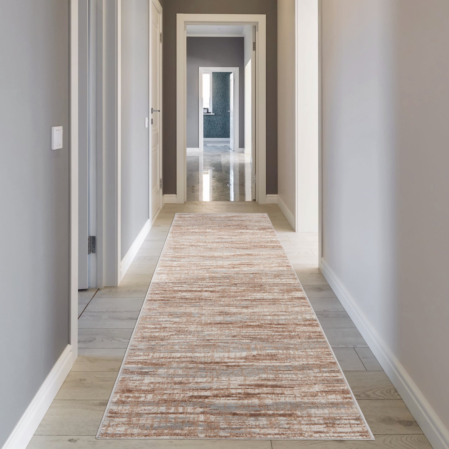 Long beige striped runner rug on light wood flooring in a gray hallway with white trim.
