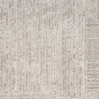 Close-up of a light gray textured rug with subtle vertical line pattern; woven flat-weave style.