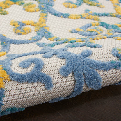 Close-up of blue and yellow ornate rug pattern on beige woven base; tufted pile, decorative area rug.
