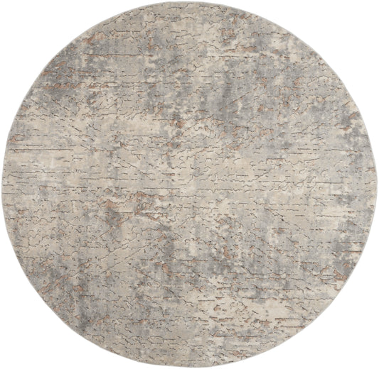 Round rug with a distressed concrete-gray and beige mottled pattern, textured surface.