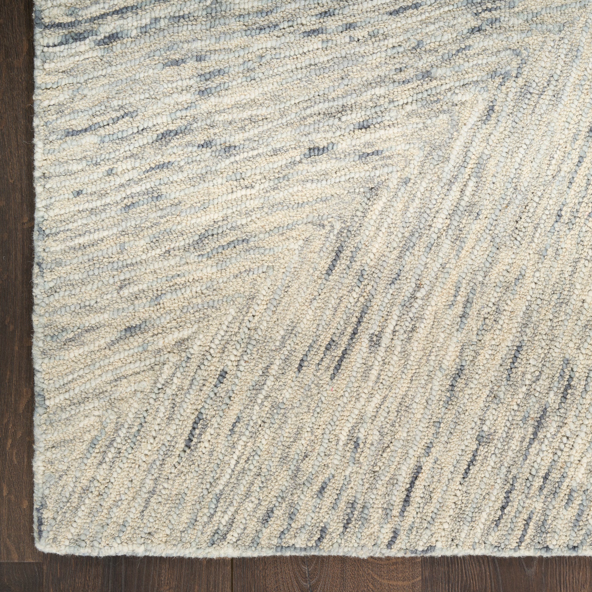 Beige & light blue shag rug with subtle chevron linear pattern on dark wood floor.