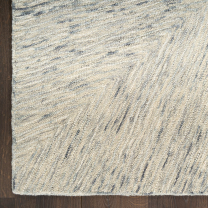 Beige & light blue shag rug with subtle chevron linear pattern on dark wood floor.