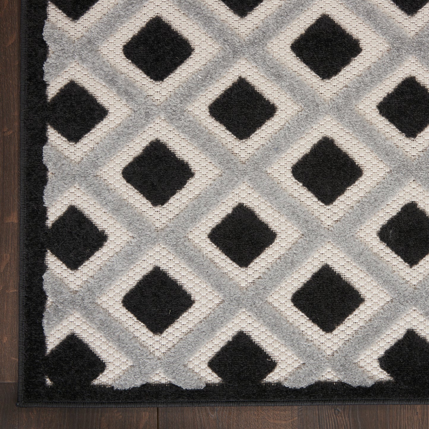 Tufted gray 12' runner rug with a black diamond lattice pattern and dark border on a wood floor.