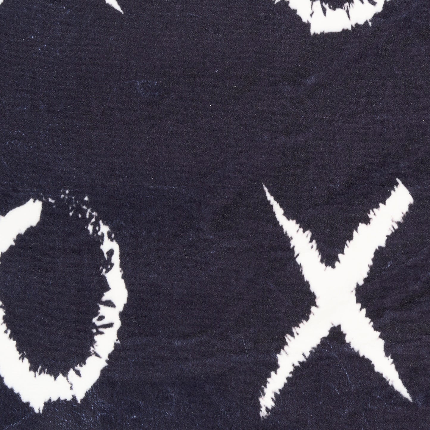 Navy rug with bold white brushstroke circle and cross pattern, distressed graphic print.