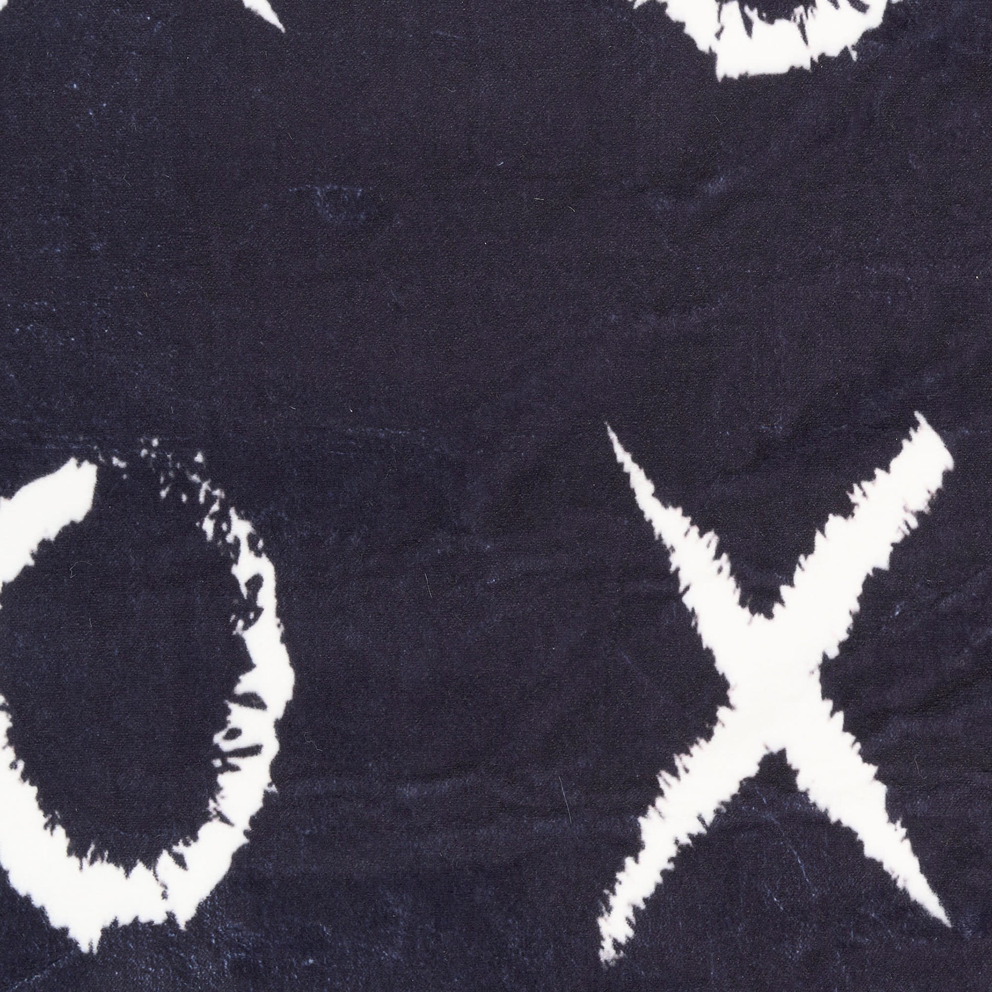 Navy rug with bold white brushstroke circle and cross pattern, distressed graphic print.