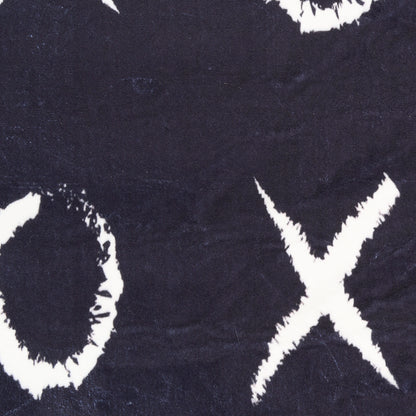 Close-up of dark navy rug with rough white circle and X motifs, bold graphic pattern.