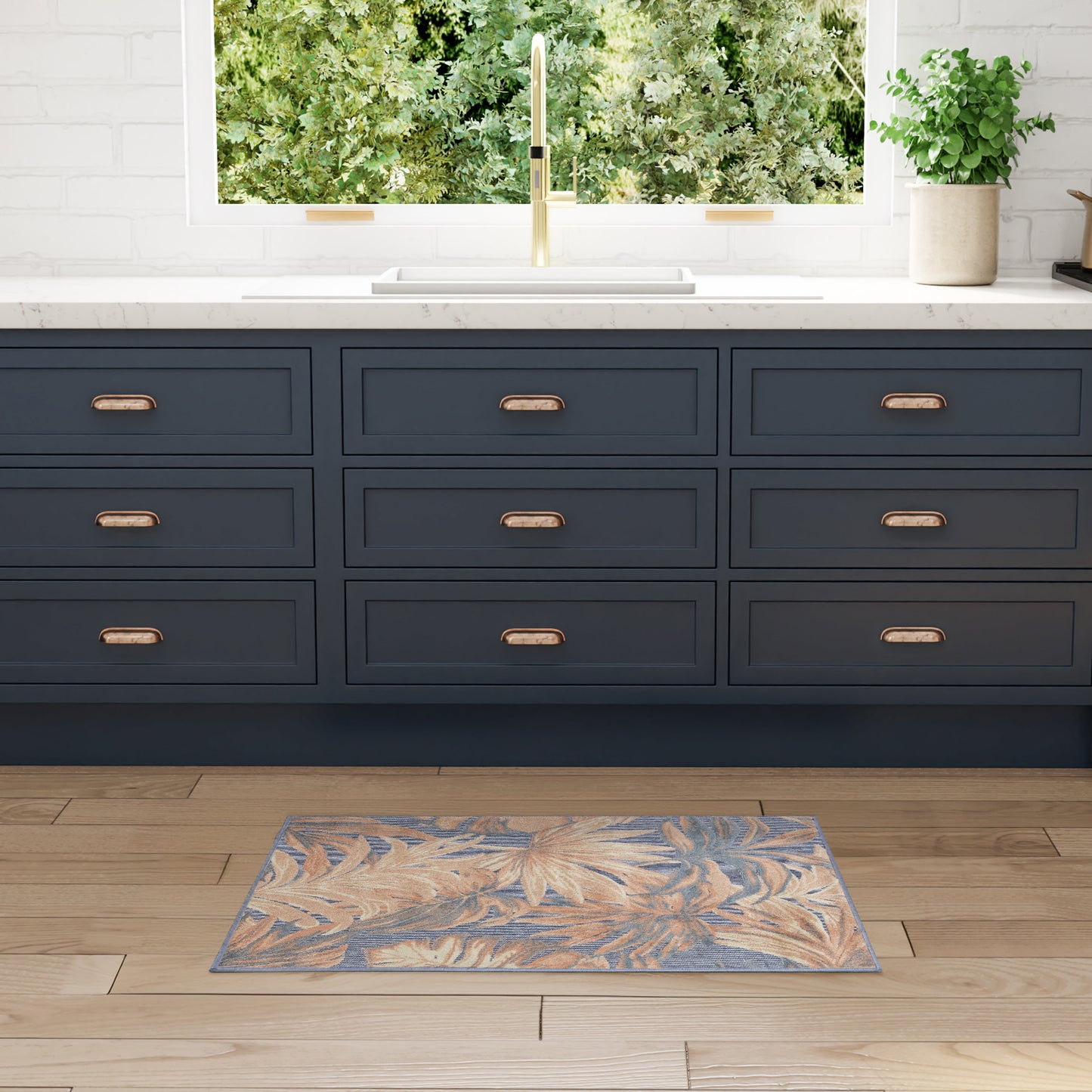 Navy blue rug with a leafy pattern on a wooden floor.