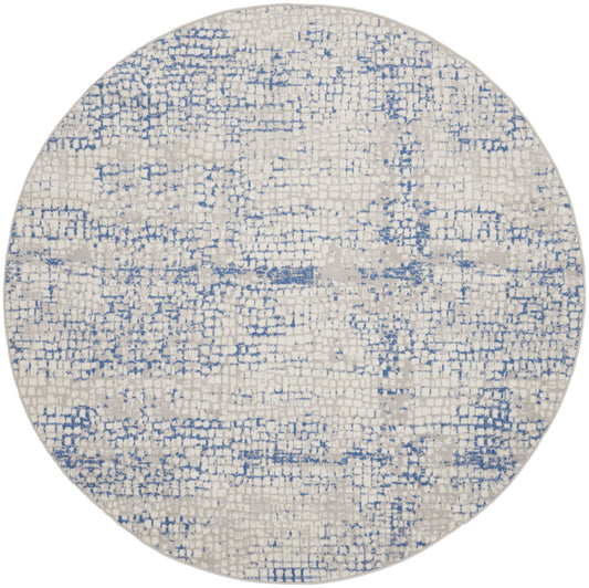 Round ivory rug with blue distressed geometric pattern; soft woven textile for living room decor.