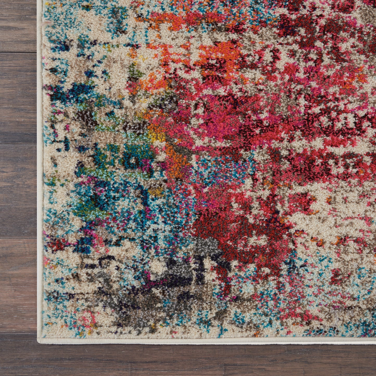 Abstract multicolor area rug with beige base and vibrant pinks, blues, reds and teals; plush high-pile texture and bound edge