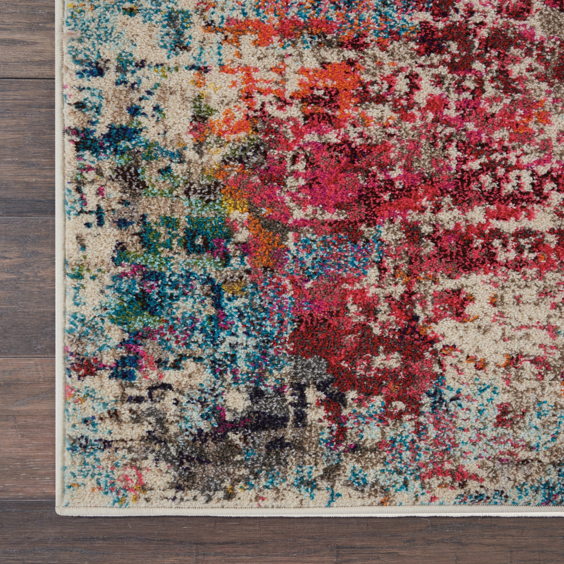 Abstract multicolor area rug with beige base and vibrant pinks, blues, reds and teals; plush high-pile texture and bound edge