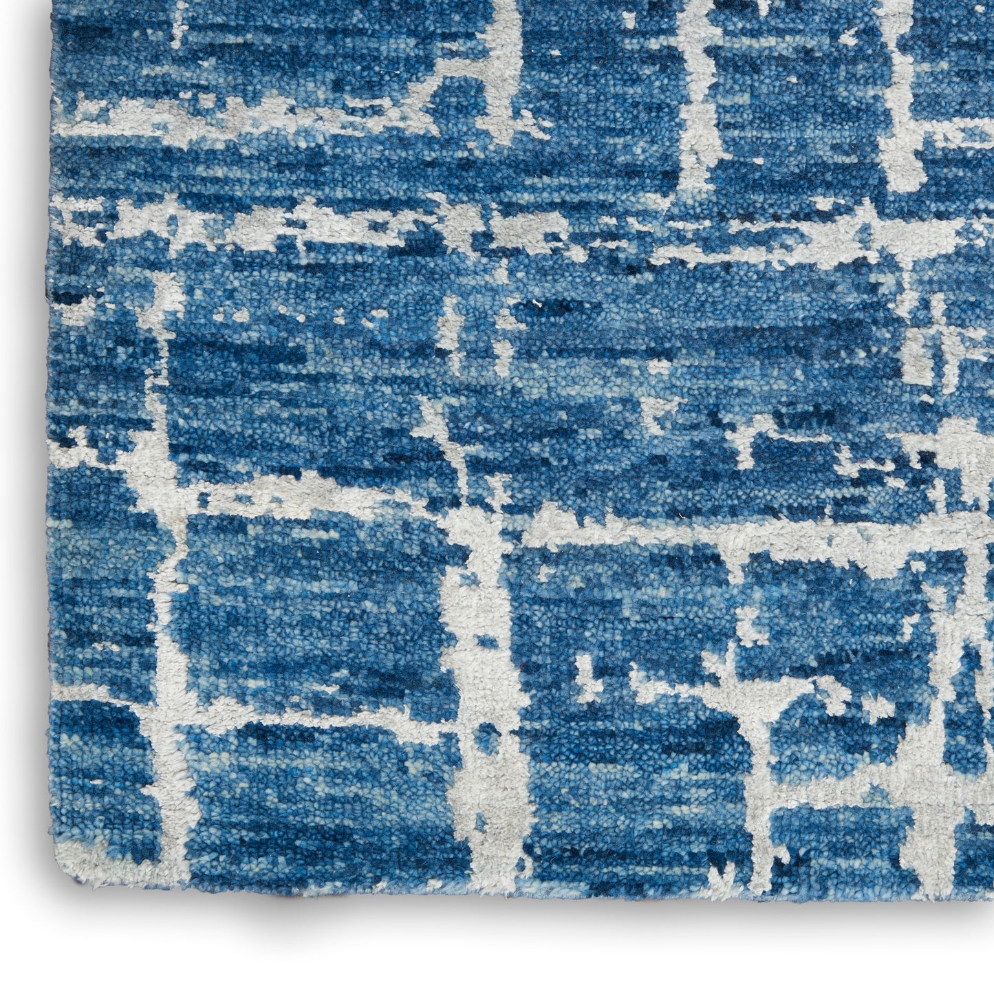 Blue and white geometric rug with distressed block pattern, plush textured pile for modern coastal decor.