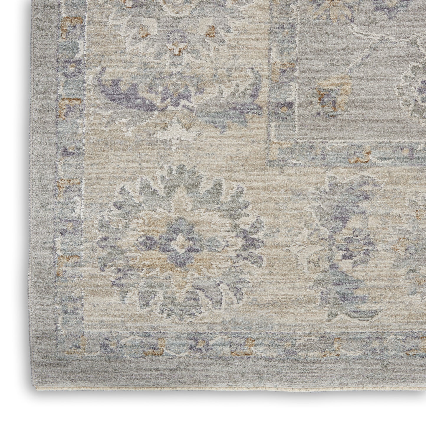 Soft, woven area rug in gray-beige with pale blue faded floral medallion design; vintage-inspired living room decor.