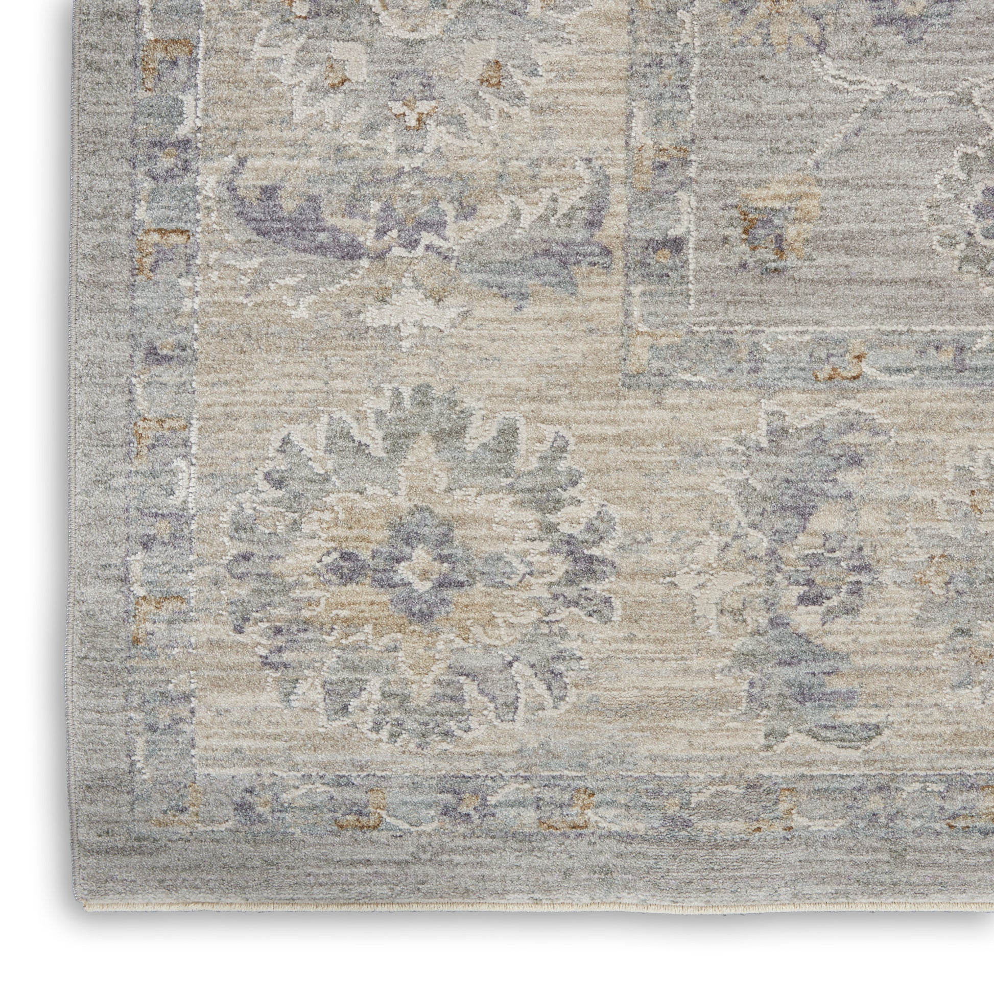 Soft, woven area rug in gray-beige with pale blue faded floral medallion design; vintage-inspired living room decor.