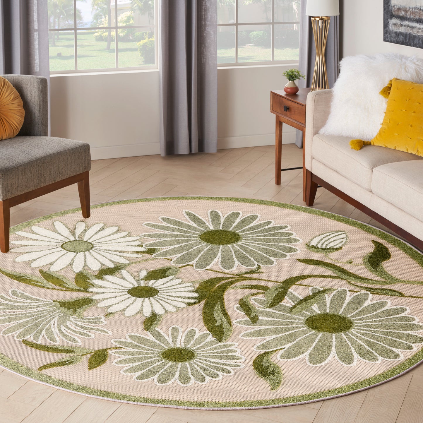 Round beige outdoor rug with white daisies and green leaves.