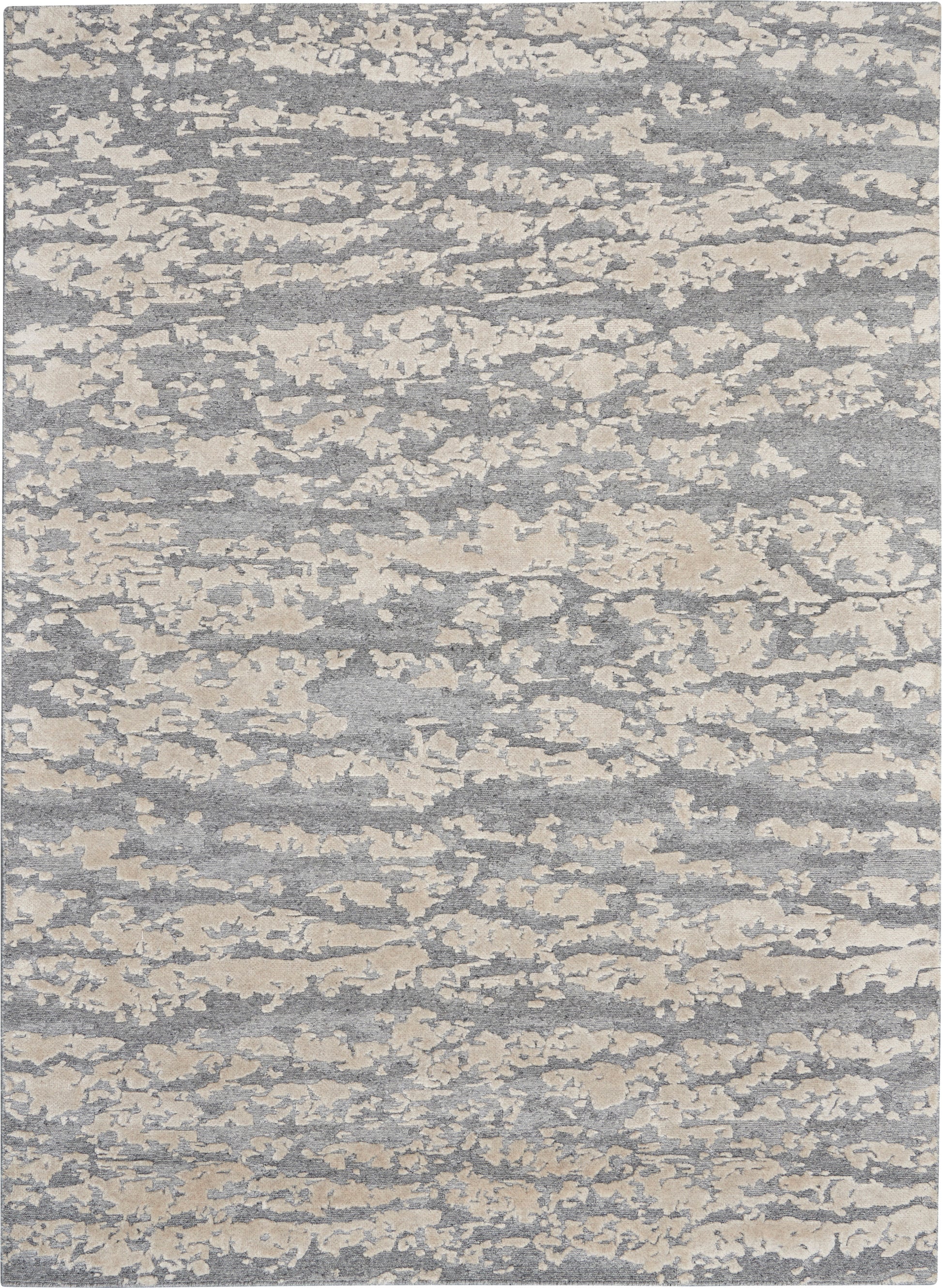 Rectangular gray-blue rug with cream cloudlike abstract pattern; soft woven texture, modern coastal style.