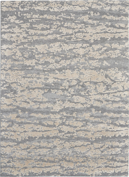 Rectangular gray-blue rug with cream cloudlike abstract pattern; soft woven texture, modern coastal style.