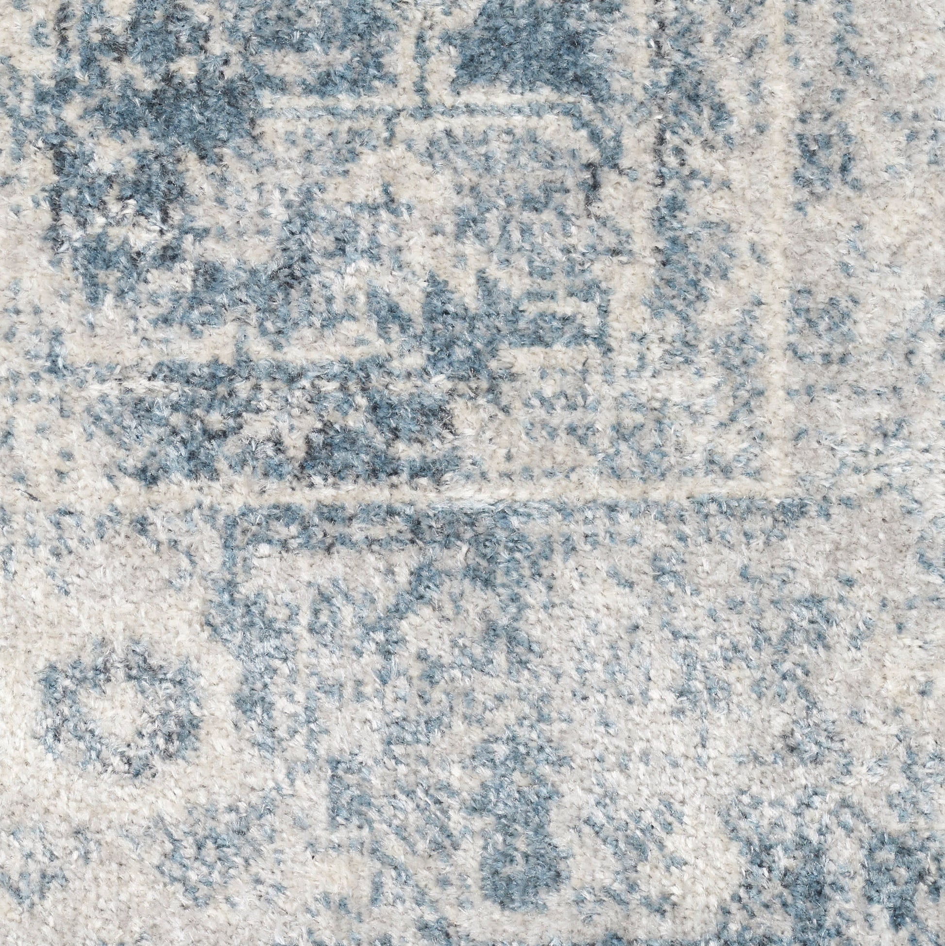 Distressed blue and ivory oriental rug close-up, faded medallion motifs and plush textured pile.