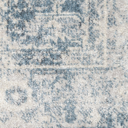 Distressed blue and ivory oriental rug close-up, faded medallion motifs and plush textured pile.