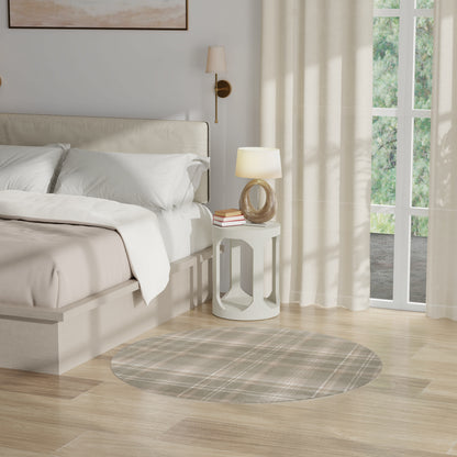 Neutral bedroom with beige upholstered bed, white linens, round white nightstand, circular wood lamp base, plaid rug.