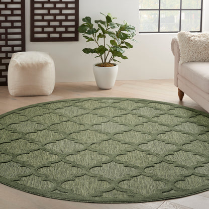 Green round woven rug with a trellis lattice pattern; textured surface in a cozy living room.