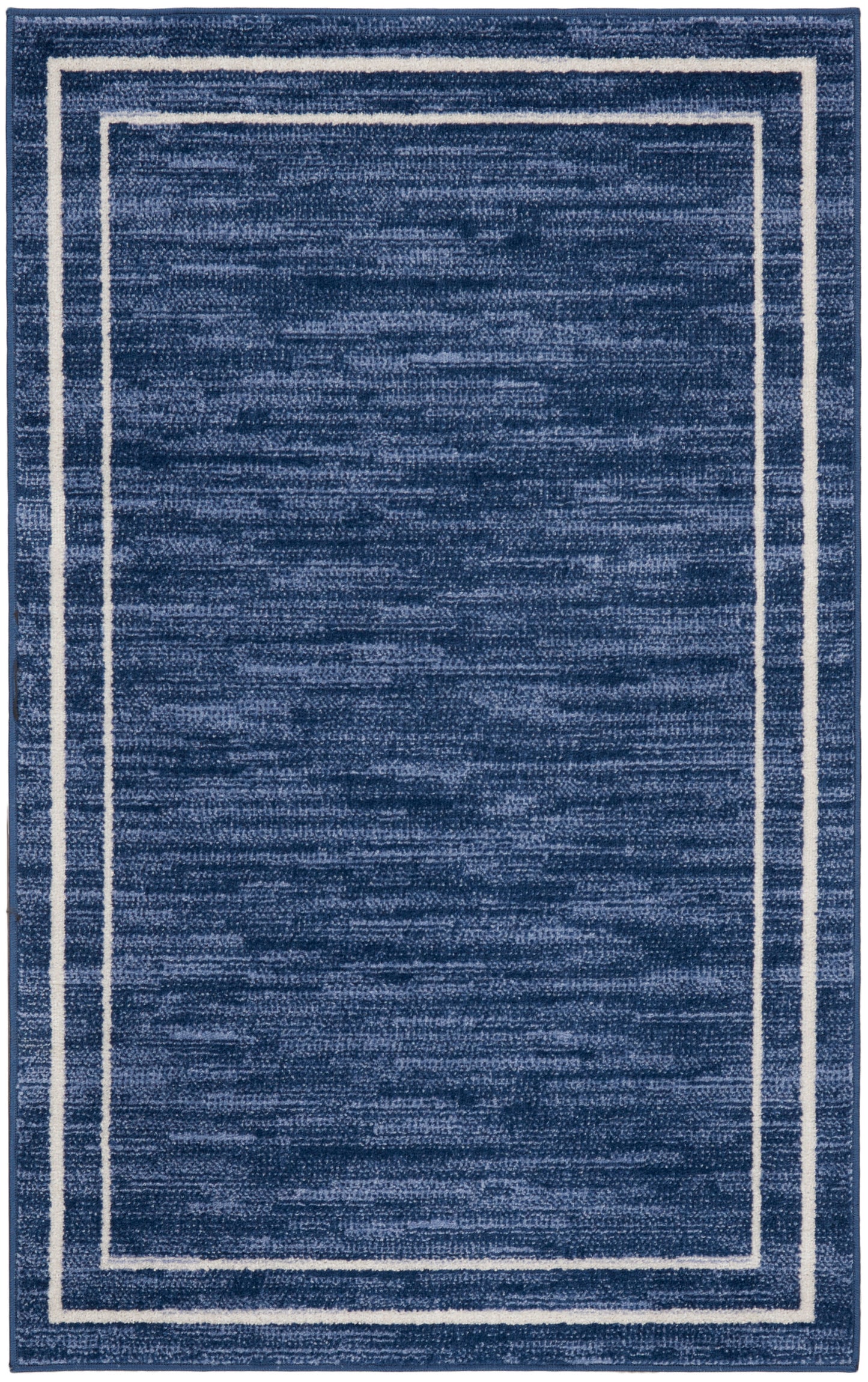 Navy blue rectangular rug with a white double-border frame near the edges; plush textured surface, modern minimalist style.