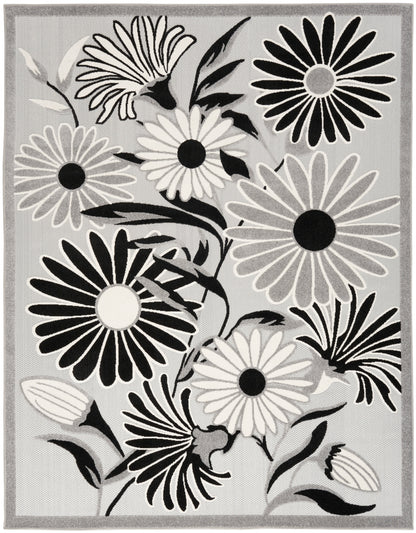 Gray rug with bold black-and-white daisy flowers, modern floral pattern and light border.