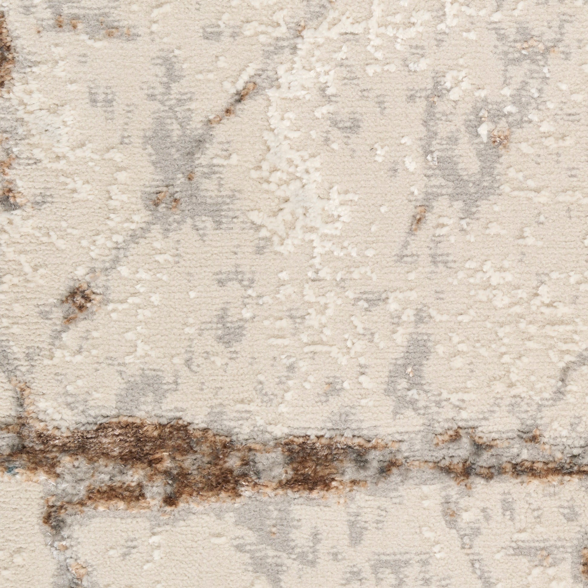 Beige abstract area rug close-up with soft cream pile, gray marbling and brown distressed stripe pattern.