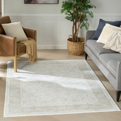 Light gray patterned area rug with ivory border in a modern living room; brown leather chair and gray sofa.