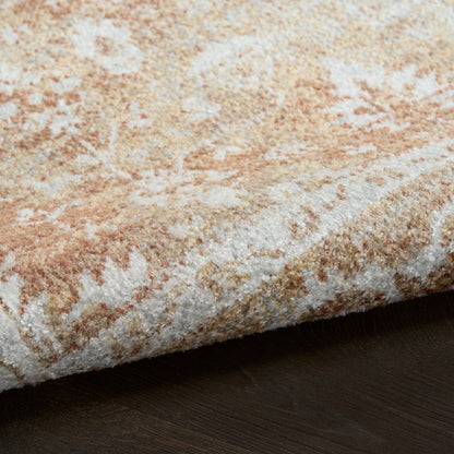 Close-up of a plush beige and cream area rug with taupe abstract pattern, edge folded on dark wood floor.