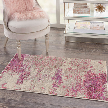 Abstract beige-pink area rug with purple accents on dark wood floor beside a light beige chair with a pink fur cushion.