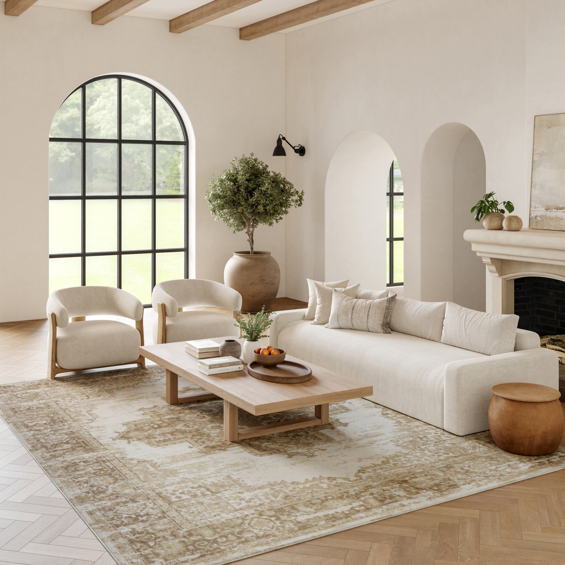 Neutral living room with cream sofa, curved armchairs, light wood coffee table, large arched window, potted tree, beige rug, and fireplace.
