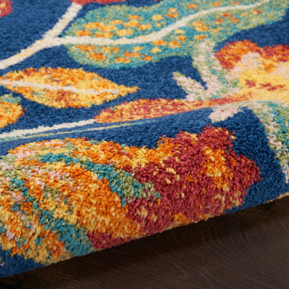 Close-up of a vibrant blue rug with orange, teal & yellow floral pattern and thick plush pile.