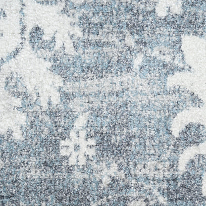 Blue & white distressed ornate rug with floral & scroll pattern & plush woven texture.