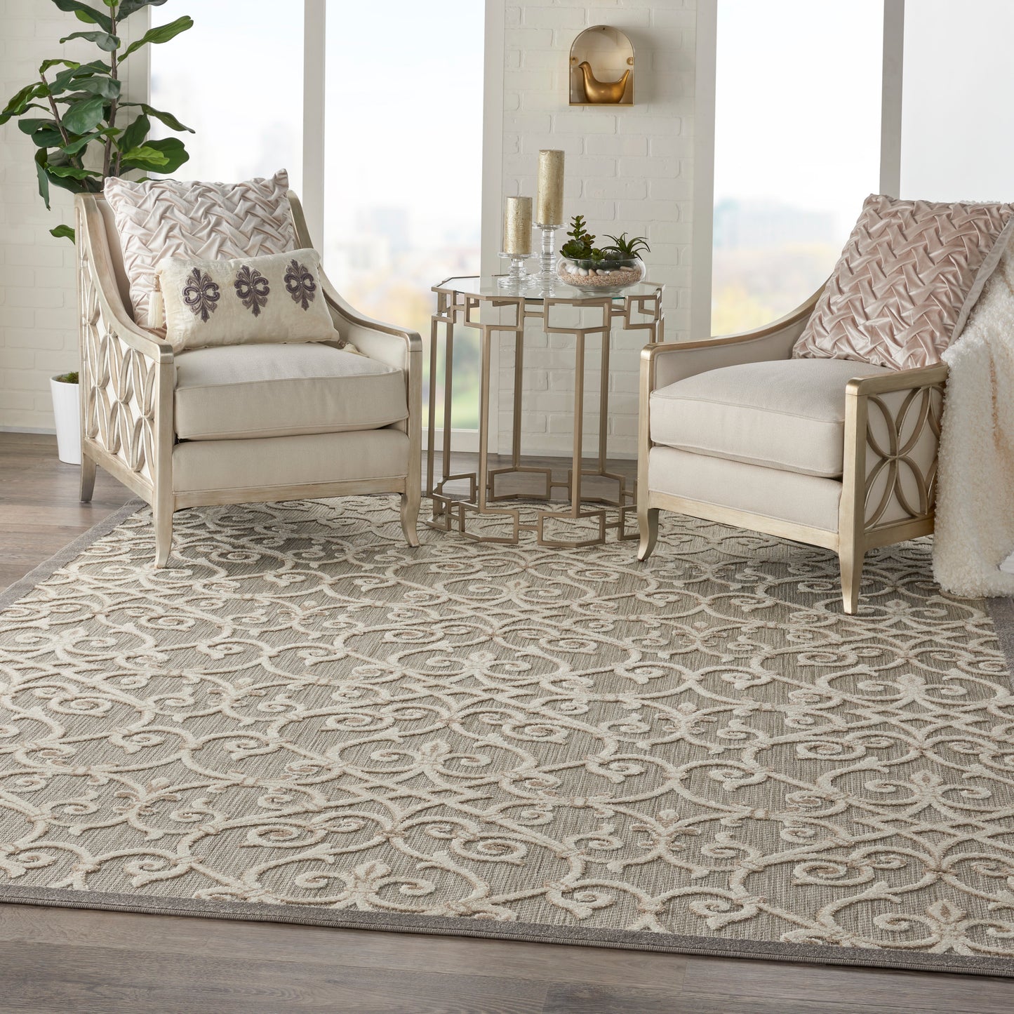 Neutral living room with two cream upholstered armchairs, carved light wood frames, and a beige patterned rug.