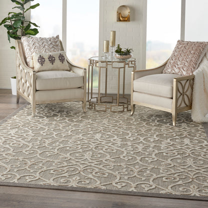 Neutral living room with two cream upholstered armchairs, carved light wood frames, and a beige patterned rug.