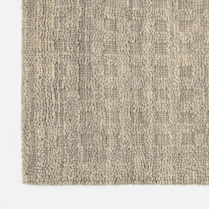 Beige-gray boucle rug with dense loop pile; soft, textured floor covering for living rooms.