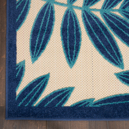Teal palm-leaf rug corner with navy border on beige field.