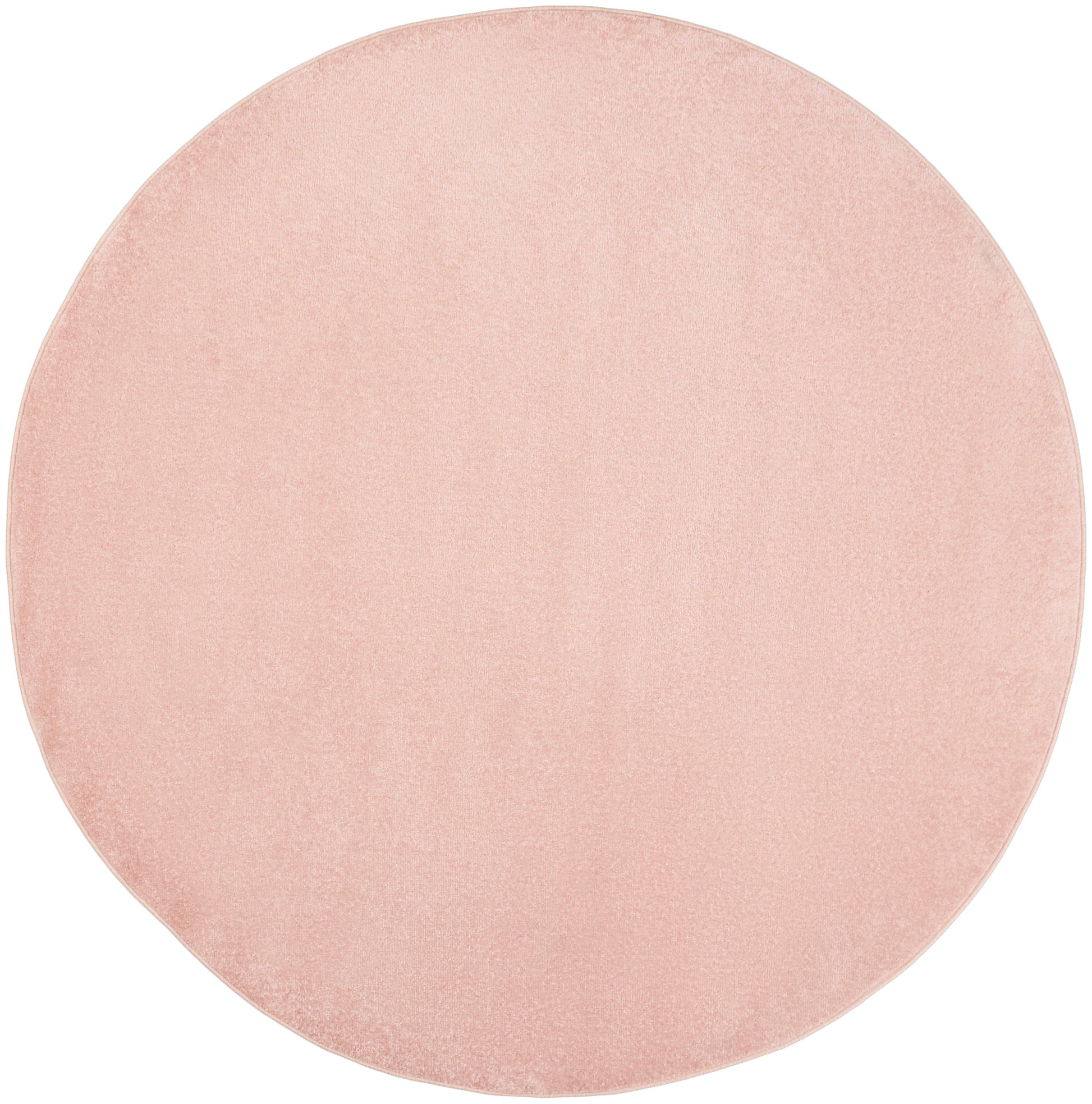 Blush pink round outdoor rug with a textured surface.