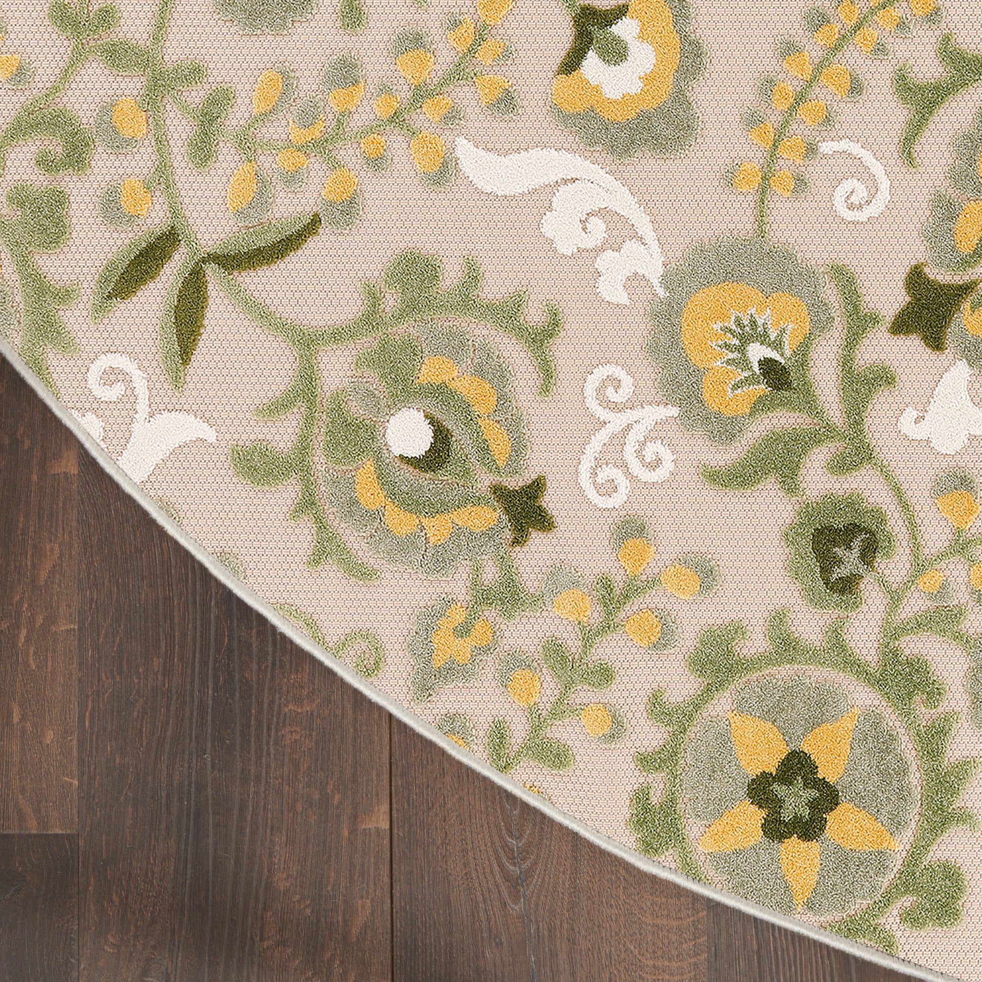 Beige floral round outdoor rug with green vines and yellow flowers.