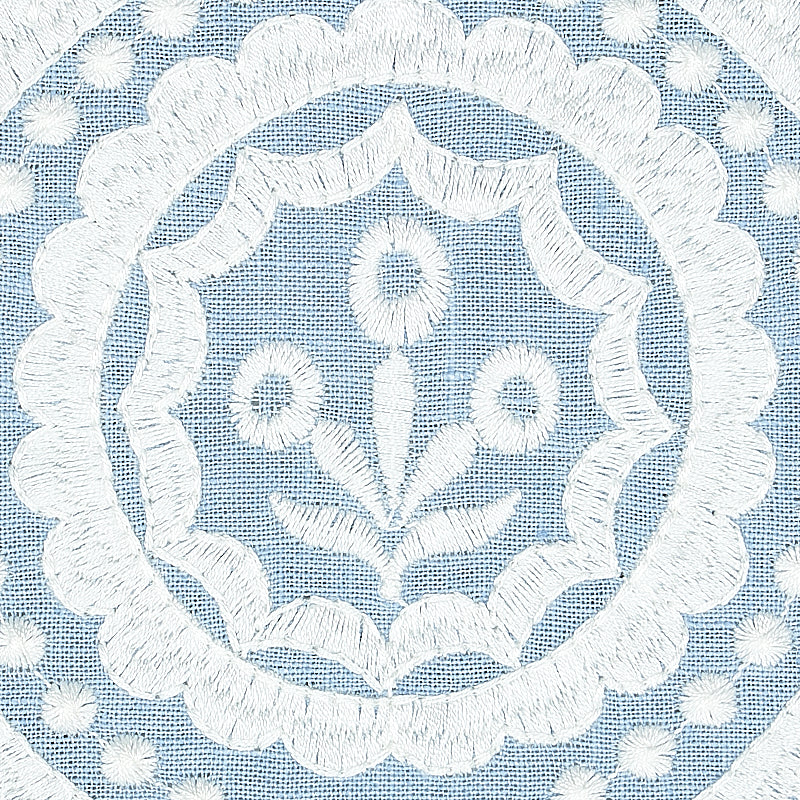 Light blue fabric with white embroidered circular medallion, scalloped border and floral center motif.
