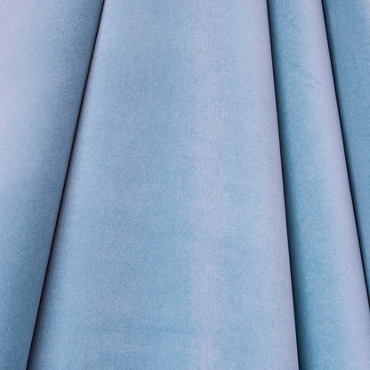 Light blue velvet fabric rolls in varying shades with soft plush texture, upholstery swatches.