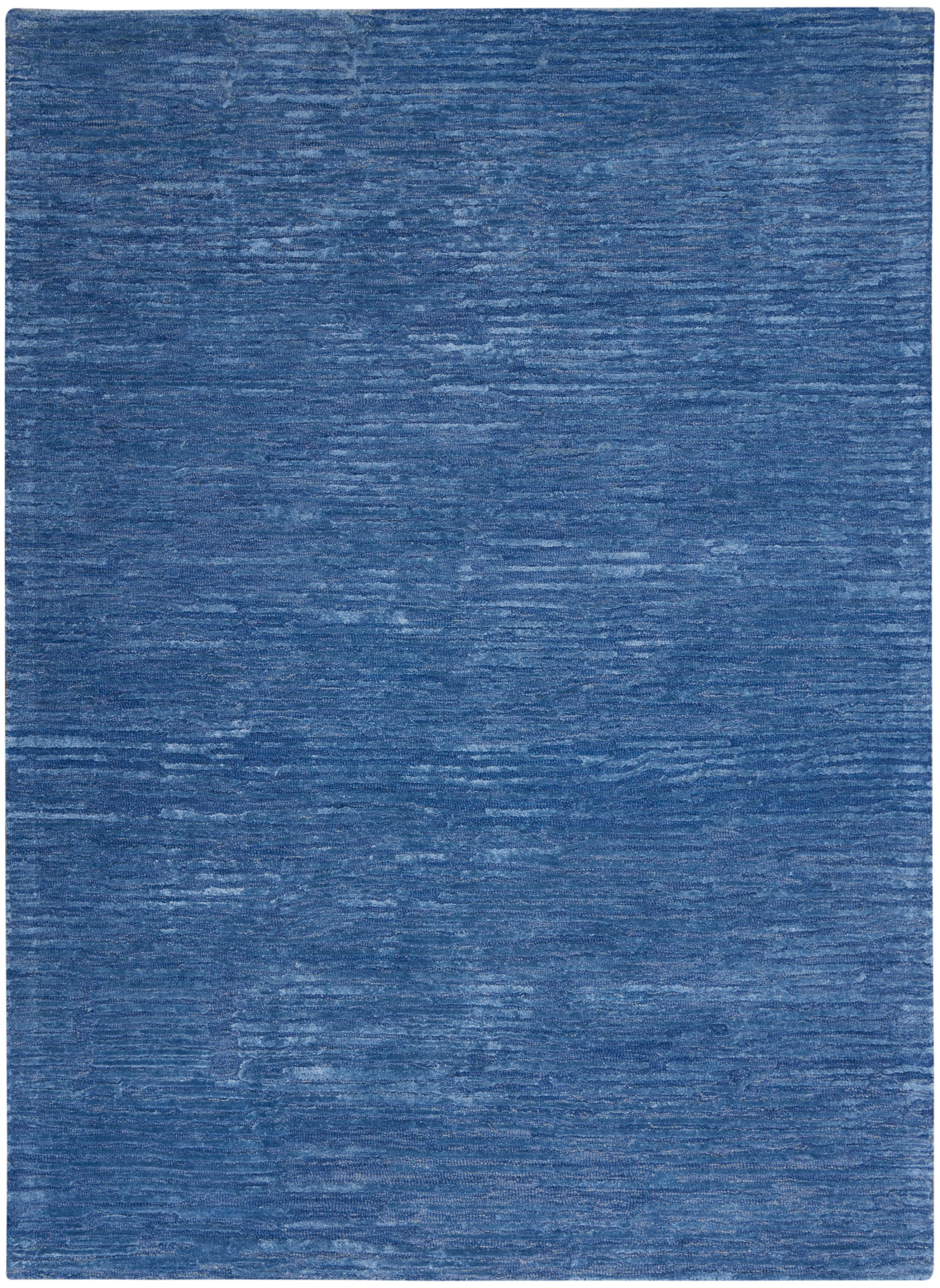 Rectangular blue rug with variegated dark and light hues and distressed woven texture.