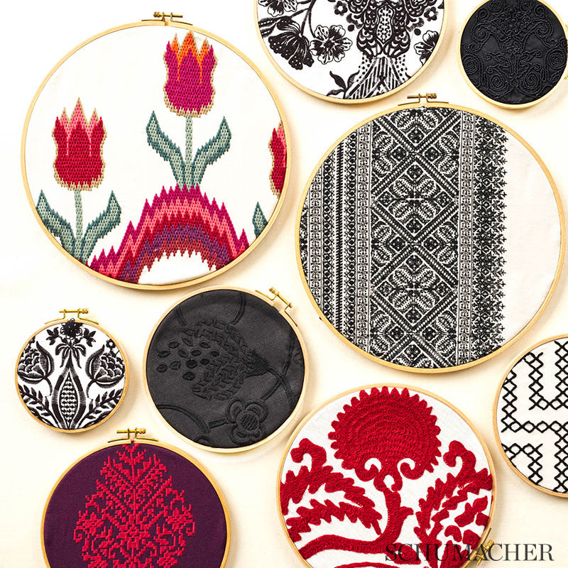 Assorted embroidery fabrics with colorful patterns: florals, black-and-white geometric, red tree, and a purple motif.
